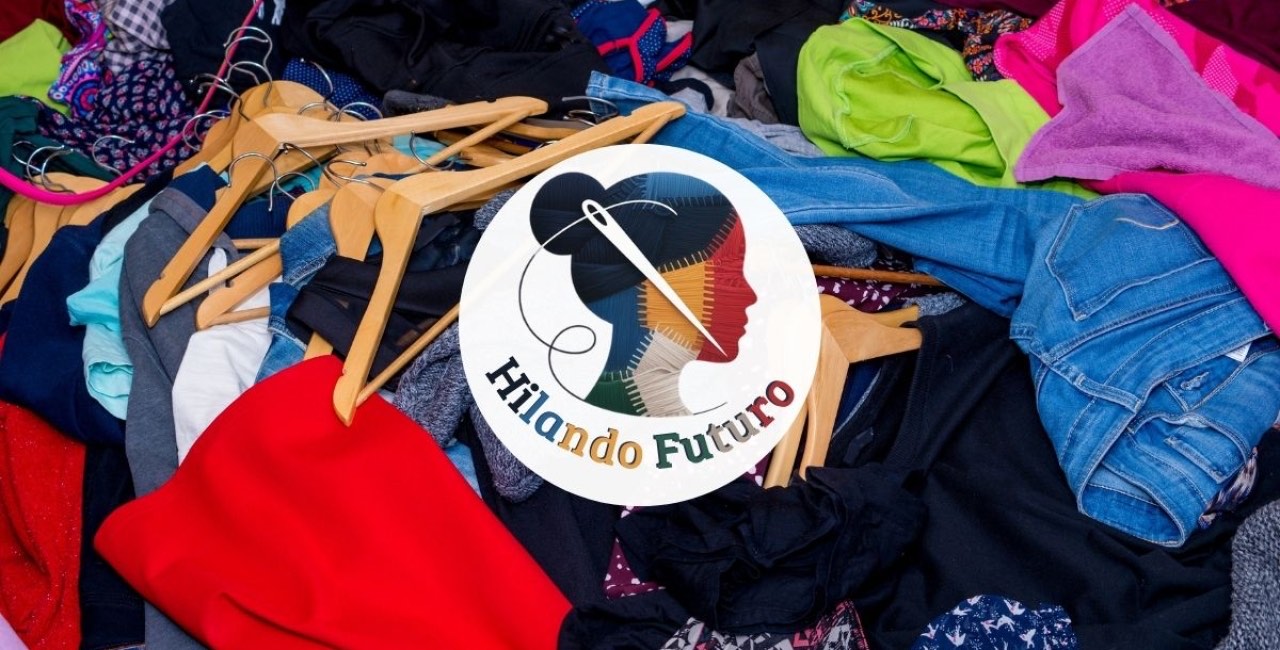 Montaña de ropa donada con el logotipo del proyecto Hilando Futuro sobrepuesto