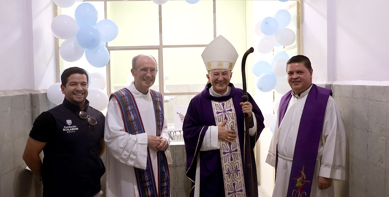 Mons. Joseph Spiteri, con báculo y casulla morada, posa junto a dos sacerdotes y un colaborador de la fundación en el nuevo consultorio