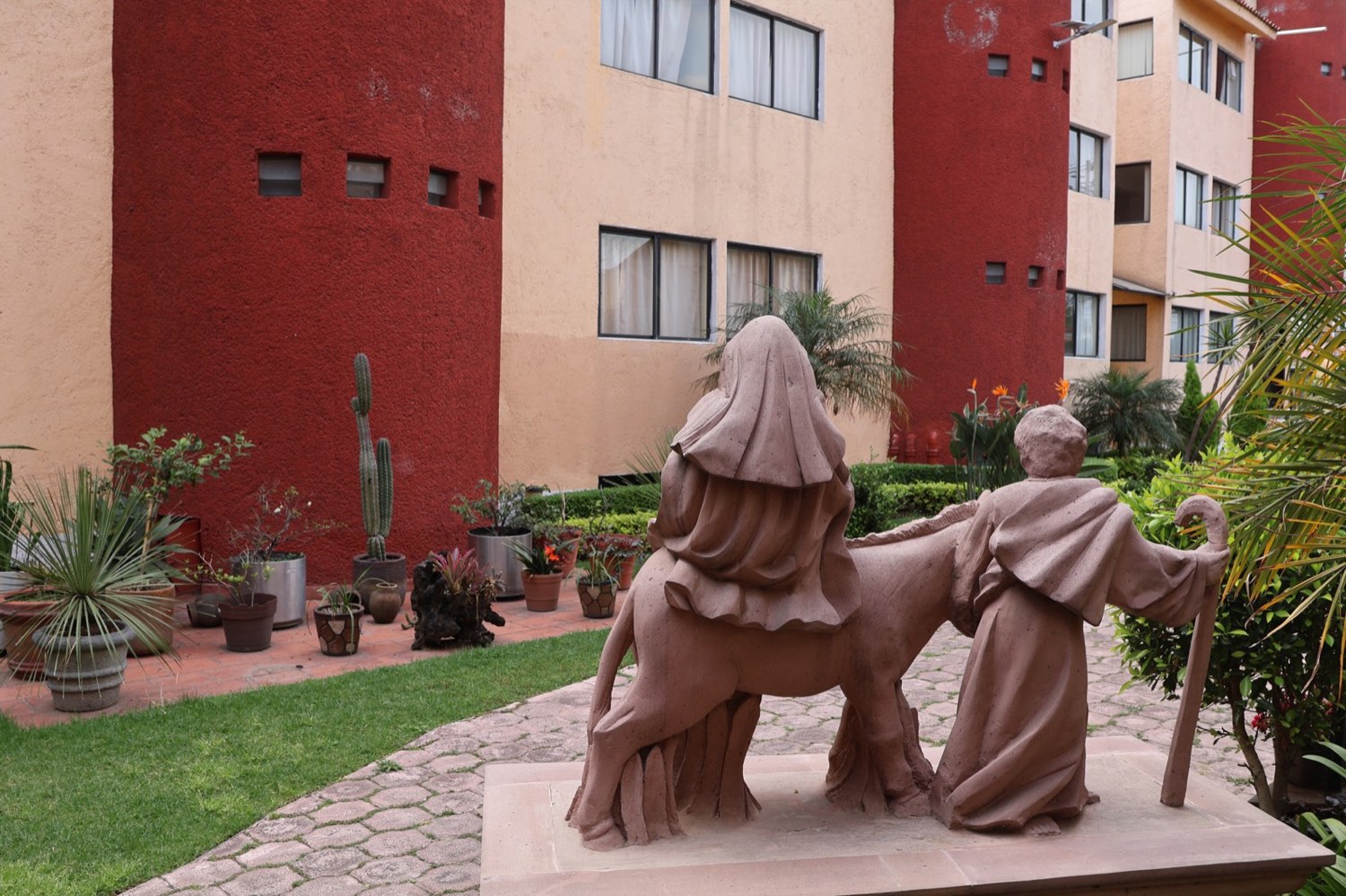 Escultura de la Sagrada Familia en camino, en el jardín de una de nuestras casas